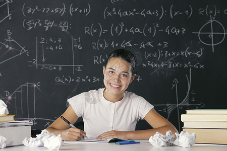 年轻女学生青少年几何学家庭作业数字数学女性智力粉笔黑板图书背景图片