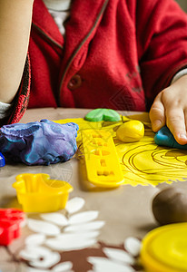 紧闭可塑胶模具和儿童手放在背景上乐趣创造力游戏桌子黏土幼儿园橡皮泥男生孩子童年背景