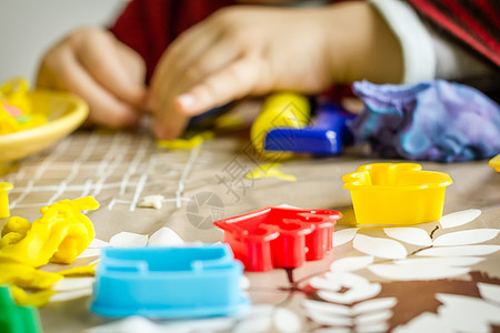 紧闭可塑胶模具和儿童手放在背景上乐趣面团玩具创造力造型游戏童年橡皮泥桌子男生背景