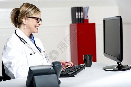 从事计算机工作的女医生医院电脑工人键盘监视器女性护士保健屏幕医师成功的高清图片素材