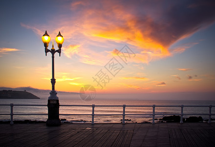 城市海滩的日落支撑景观地平线海洋岩石灯柱街道集锦海岸线游客背景图片