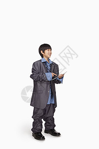 男孩装扮成商务人士使用平板电脑高清图片