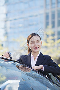 女商务人士站在汽车旁 看镜头公司高清图片