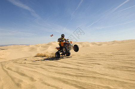 在沙漠里骑轮车的年轻四级自行车骑手背景图片