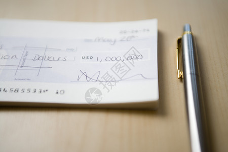 高端钢笔一张一百万元的支票 放在桌对齐时笔旁边背景