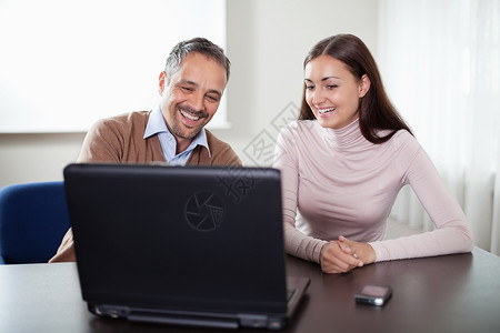 两个在笔记本电脑上工作的快乐商业同事快乐的高清图片素材