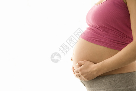 怀着白种手抱着肚子的孕妇的侧边视角中部位新生活闲暇孕妇装怀孕成人女士水平裁剪待产工作室背景图片