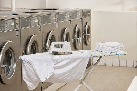 洗衣场景在洗衣店用洗衣机熨烫衣服板背景