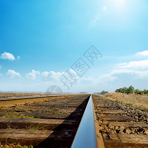 距离线在旧铁路上 蓝天的阳光下背景