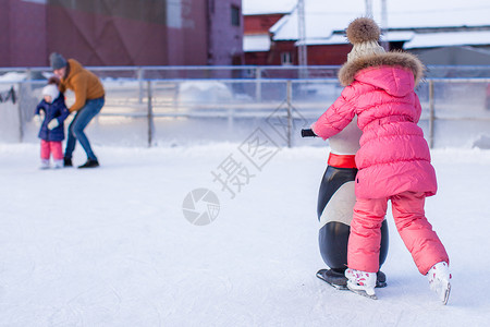 玩滑冰可爱的小女孩在冰场滑冰冰鞋女儿小姑娘学习套装企鹅女孩运动速度数字背景
