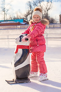 玩滑冰快乐的小女孩学习滑冰 在水晶上女儿溜冰者数字手套速度幸福女性小姑娘溜冰场婴儿背景