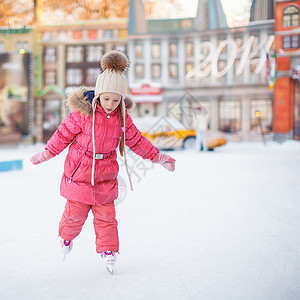 滑冰的小女孩可爱快乐的小女孩 享受滑冰在冰场数字溜冰场企鹅婴儿童年小姑娘速度孩子微笑套装背景