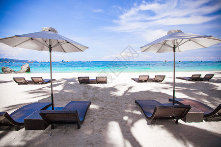 白雨伞和沙滩背景的椅子 蓝海阳光季节酒店海岸晴天阳伞地平线天空天堂遮阳棚背景图片