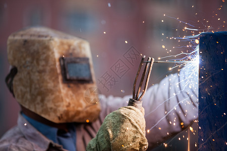 保护面罩焊接金属结构中的焊接焊机工人生产工作服工厂头盔男性工具作坊力量金工火焰设备高清图片素材