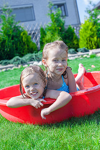 两个小妹妹在阳光炎热的一天 在游泳池里玩耍和泼水晴天娱乐运动幸福孩子享受女孩微笑喜悦飞溅安静的高清图片素材
