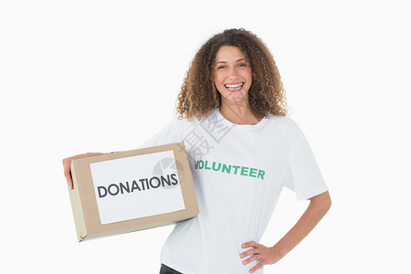 带着一箱手放在屁股上的捐赠品的微笑志愿者背景图片