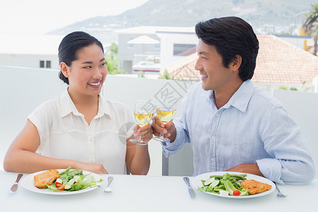 快乐的一对夫妇一起喝白酒吃饭女性微笑空闲盘子夫妻晚餐家庭家庭生活男性住所背景图片