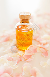 粉色液体特写必要的石油和玫瑰花瓣护理植物化妆品温泉奢华香味身体疗法治疗头发背景