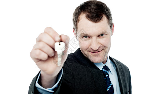 英俊的房地产商卖房钥匙套装高清图片素材