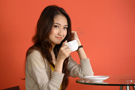 亚裔年轻女子 可爱的饮酒妇女拇指快乐女孩女性女士工作室手势背景图片