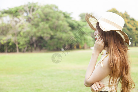 戴帽子在电话上说话的女人成人绿色女士手机黑发阅读思考女性讲话互联网移动的高清图片素材