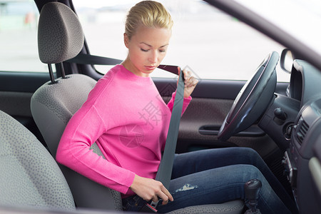 推着车女孩美丽的女人系紧安全带预防车辆女性旅行运输司机汽车座位成人腰带背景