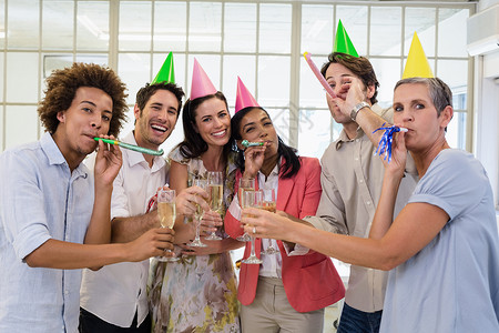 以香槟和派对角庆祝的零星商业团队女性人士工作女士酒精长笛混血休闲职员同事背景