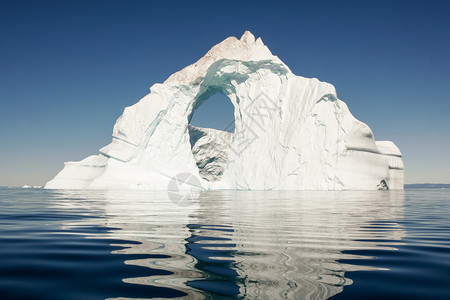 一片孤单的冰山坐落在平原的深蓝海中高清图片