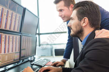 股票交易商在看电脑屏幕数字金融图表技术人士团队库存市场贸易投资者指数高清图片素材