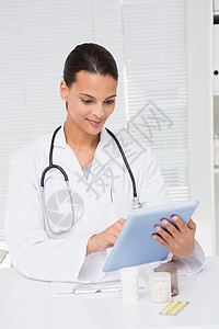 使用平板电脑的医生药片触摸屏医务室服务处方从业者滚动快乐实验女性背景图片
