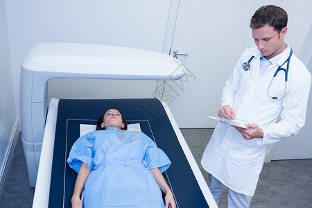 专治医生对病人进行放射摄影x光技术专注放射科从业者说谎卫生女士男性职场背景图片