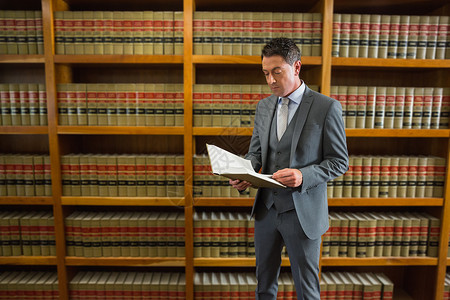 律师在法律图书馆阅读书大学教科书书架法律男性架子专注男人学习高等教育背景图片