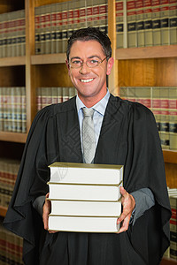 律师在法律图书馆持有书籍男人校园体积教科书书架长袍知识大学学习微笑背景图片
