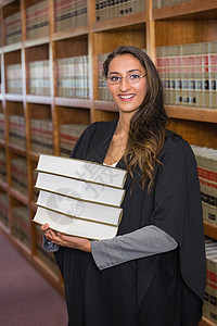 漂亮的律师在法律图书馆看相像机女性女士校园大学高等教育学习混血知识体积长袍背景图片