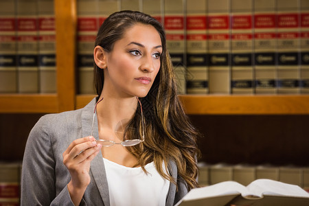 法律图书馆的美貌律师阅读大学体积学校女士学习专注架子书架知识校园背景图片