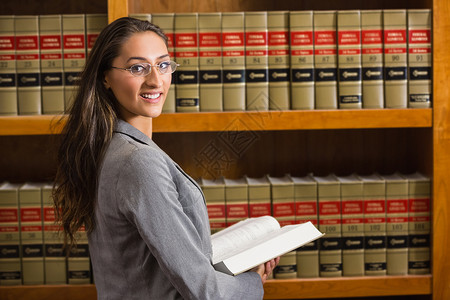 律师在法律图书馆看相像机书架知识教科书高等教育混血校园架子学校大学女性背景图片