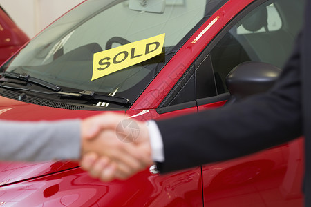 人在一辆被卖车前面握手职业销售协议代理商女士运输陈列室营业员专业顾客背景图片