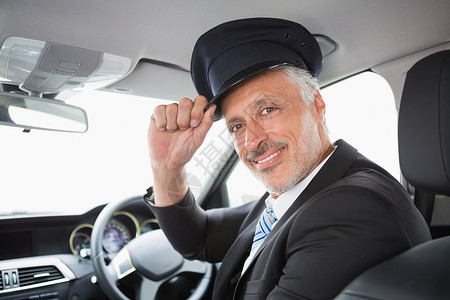 英俊的司机在相机上微笑制服汽车零件闲暇套装运输轿车快乐陆地工作背景图片