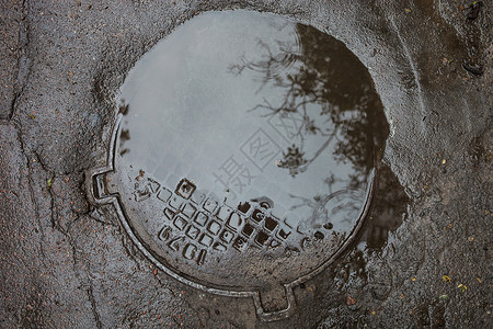 公用设施沥青表面坑洞的水坑反射孵化水分空间金属检查圆圈路面城市铺路背景