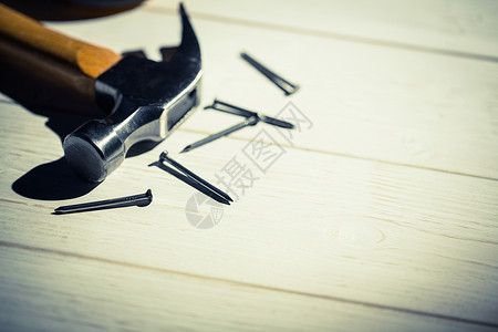 铁锤和钉子 放在桌上工作工作台阴影指甲工具锤子背景图片