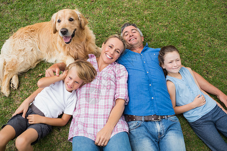 幸福的一家人带着狗笑着对着摄影机微笑男性父亲阳光儿子浅色孩子童年女士金发女郎男人家畜高清图片素材