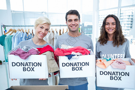 捐衣服持有捐赠箱的志愿者朋友志愿男性女性盒子福利微笑女士衣服社会团队背景