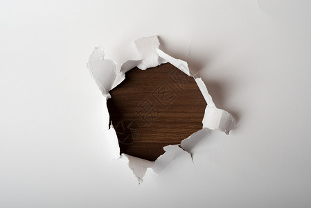 中间有洞的纸片中心边缘木头特写视图床单棕色空白背景图片