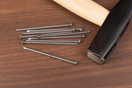 铁锤和钉子在桌上木头工具十字工作尺寸视图钉头特写手工具桌子背景图片