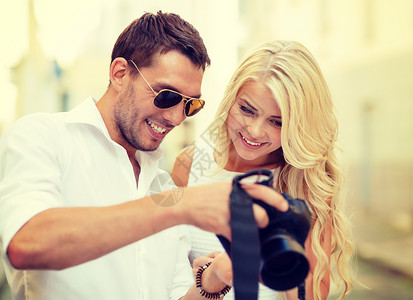 带相片照相机的一对微笑的情侣游客相机幸福男人蜜月女士照片技术周年家庭背景图片