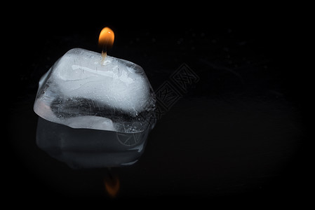 火焰和冰宏观黑色反射矛盾概念灯芯冰块背景蜡烛立方体高清图片