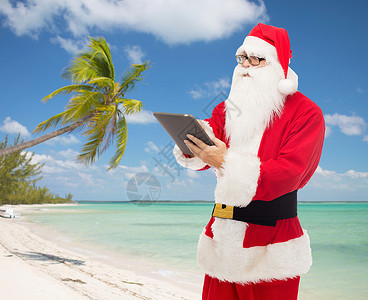 穿着圣塔礼服的人 用平板电脑胡须快乐互联网庆典海滩技术蓝色戏服海洋男人尼古拉斯高清图片素材