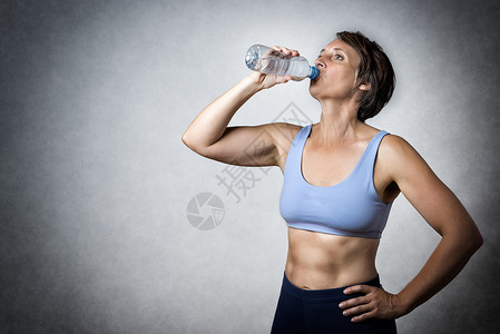 中年妇女饮酒衣服耐力健身房白色母亲瓶子身体女孩女性工作室背景图片