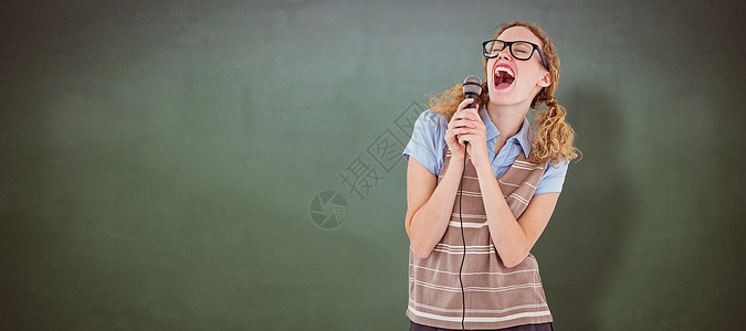 怪怪的时装女歌唱在麦克风里黑板眼镜毛衣极客课堂绿色学校享受娱乐性娱乐背景图片