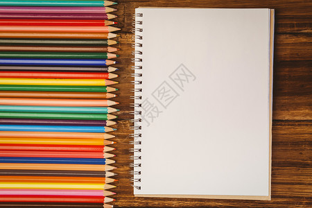 桌上带有注纸的彩色铅笔背景图片